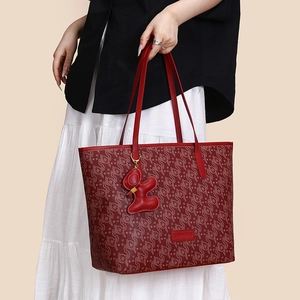 Detailansicht einer roten Tote Bag mit Ruyi-Muster und einem süßen Leder-Hasenanhänger
