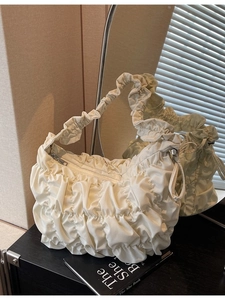 Chic off-white cloud tote bag with ruched texture and metallic zipper in home setting