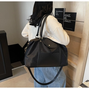 Grand sac cabas noir avec bandoulière réglable présenté sur un mannequin de dos