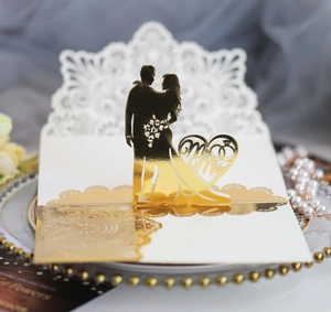 Macro view of laser-cut 3D wedding card with gold foil Mr & Mrs silhouette