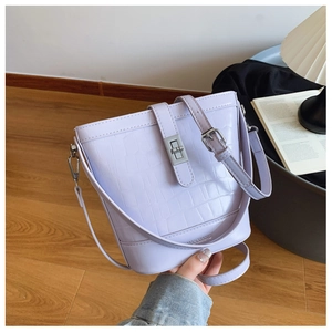 Detailed view of lavender crocodile pattern bucket bag with silver clasp and handle