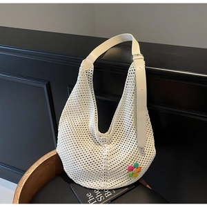 Close-up of white crochet tote bag showing woven mesh texture and colorful floral detail