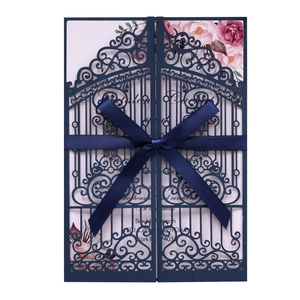 Elegant navy blue laser-cut wedding invitation with silk ribbon bow and floral inner card