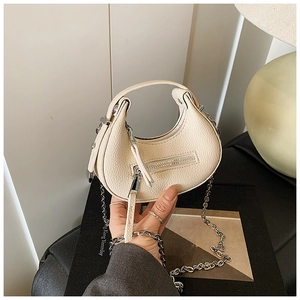 Macro shot of cream white micro bag in lychee pattern leather with silver chain strap