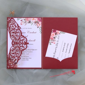 Detail of laser-cut burgundy wedding invitation set with floral inner card and RSVP