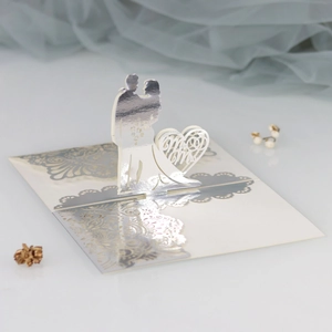 Detail of laser-cut 3D wedding invitation with silver Mr & Mrs heart silhouette