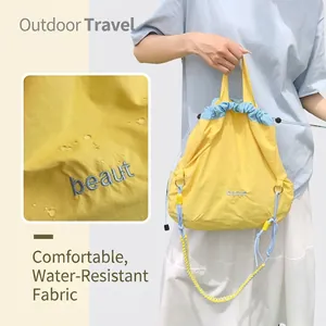 Detail of waterproof nylon fabric on a two-tone drawstring bag with beaut embroidery