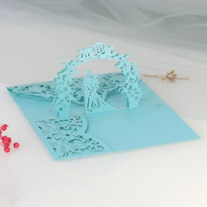 Detailed laser cut 3D wedding invitation featuring light blue floral arch and bride groom silhouette