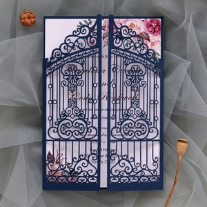 Detail of laser-cut navy wedding invitation gate and floral inner card on grey fabric