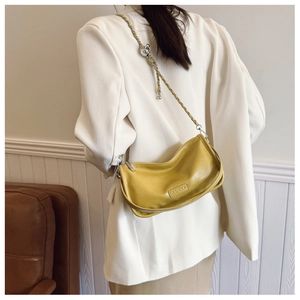 Detail of ginger leather shoulder bag with silver chain strap and metal brand logo