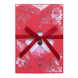 Detail of red laser-cut wedding invitation with silk ribbon and illustrated insert card