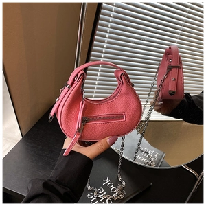 Detail of pink lychee leather crescent bag with silver chain and stylish zipper