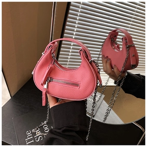 Detailed macro view of pink pebbled leather mini half-moon bag with elegant chain strap