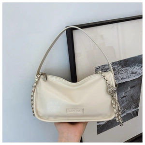 Close-up of cream leather shoulder bag featuring silver woven chain and brand logo detail