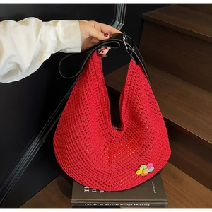 Detail of red hollow knit tote with rainbow flower and black leather strap