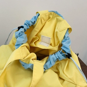 Detailed interior of nylon drawstring crossbody bag showing yellow-blue dual color and velcro pocket