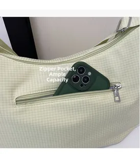 Dettaglio della tasca posteriore con zip su una borsa tote a quadri verde chiaro