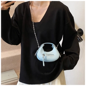 Detail of light blue crescent bag with lychee grain leather and silver chain strap