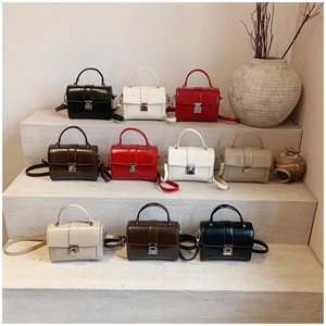 Multi-color minimalist small crossbody bags displayed on stone steps in a studio setting