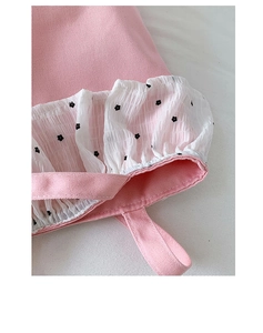 Close-up of pink canvas bag with ruffled white floral trim and detailed stitching