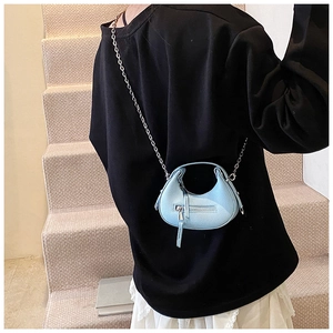 Detail of sky blue mini crossbody bag with litchi texture leather and silver chain strap