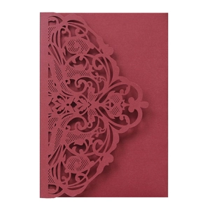 Detail of laser-cut burgundy lace card sleeve with intricate floral vine patterns
