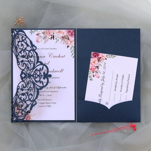 Macro detail of laser-cut navy wedding invitation set with floral card inserts