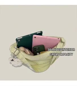 Dettaglio interno della grande borsa tote a scacchi verde con tablet e vari accessori