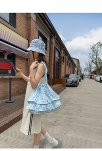 Detailed view of a blue checkered shoulder bag with layered ruffles and matching bucket hat