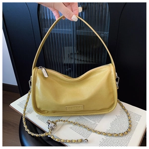 Detailed close-up of yellow baguette bag with silver metal ball chain and C&HEKA logo