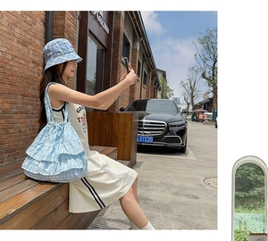 Close-up of blue and white plaid canvas tote bag with multi-layer ruffle design details