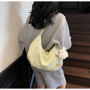 Dettaglio borsa hobo gialla a quadretti con ciondolo a coniglio in peluche bianco