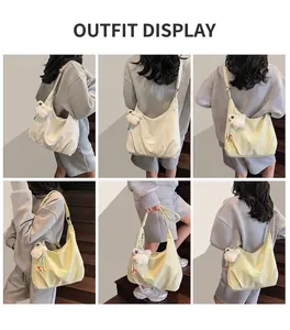 Model wearing a large canvas crescent shoulder bag with a cute white plush bear pendant