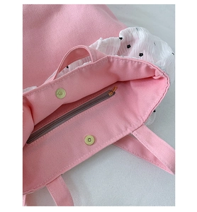 Detail of pink canvas tote showing interior metal zipper and magnetic snap closure