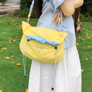 Detail of yellow and blue nylon crossbody bag with drawstring and adjustable strap