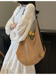 Large beige woven hollow-out tote bag with floral patch and black leather shoulder strap