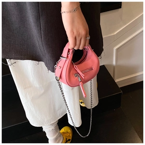 Detailed shot of pink pebble leather mini crossbody bag with silver chain strap