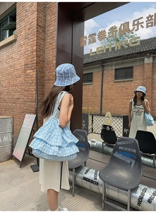 Detail of blue plaid bucket hat and matching multi-layered ruffle shoulder tote bag