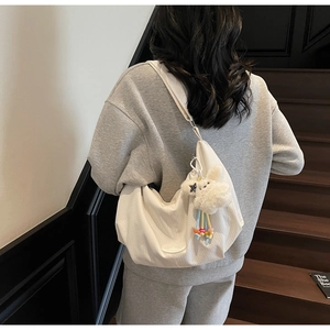 Dettaglio della borsa hobo bianca testurizzata con un ciondolo a coniglio in peluche