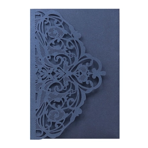 Macro shot of dark blue laser cut invitation card with intricate floral pattern
