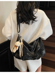 Black chain shoulder bag with plush bear charm and vintage marble texture finish