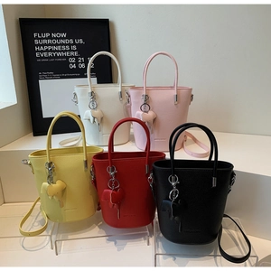 Detail shot of five colored bucket bags in pebble leather with elephant charms on stairs