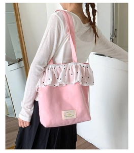 Detailed shot of pink canvas tote bag with floral ruffle trim and decorative patch