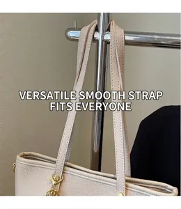 Close-up of cream pebble leather tote bag featuring long straps and gold metal hardware