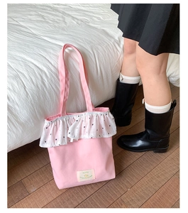 Detailed shot of pink canvas tote bag with white ruffle lace and floral patterns