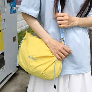 Detail of yellow nylon drawstring bag with blue beaut embroidery and cord strap
