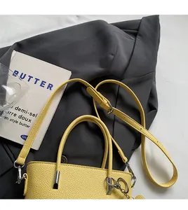 Detail view of yellow litchi texture bucket bag with adjustable shoulder strap and handles