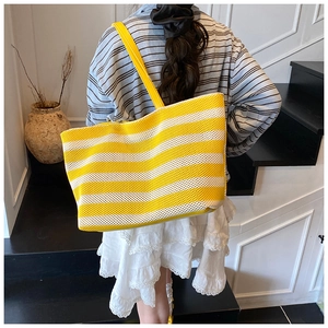 Dettaglio della borsa tote in maglia a righe gialle e bianche con tracolla in pelle