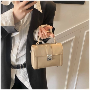 Detailed macro view of beige patent leather shoulder bag with a silver metal clasp