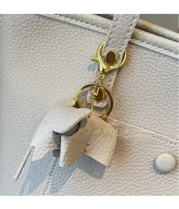Close-up of creative lychee grain leather charm with gold metal clasp on a tote bag